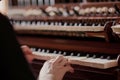 view over the shoulder of an organist pressing organ keys