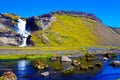 View over small river with boulders and stones on water fall against blue sky Royalty Free Stock Photo