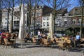 View over square with exterior cafes, people sitting outside, old typical buildings background Royalty Free Stock Photo