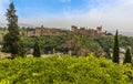 A view over the treetops of the Albaicin district of Granada towards the Alhambra Palace and the Sierra Nevada mountains