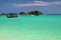 View over turquoise bay contrasting with blue sky on tiny  island with long tail boats on Ko Lipe, Thailand Royalty Free Stock Photo