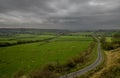 A view over undulating farmland with a road leading away from the camera.