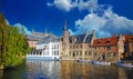 View over water canal on pier with tourist sightseeing boats, medieval buildings, green tree against clear blue autumn sky Royalty Free Stock Photo