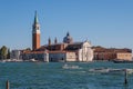 view over the water to some large buildings with a clock tower in the distance Royalty Free Stock Photo