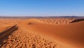 View over the wind shaped sand dunes of Erg Chebbi with tracks and footprints in the sand near Merzouga, Morocco, Africa. Royalty Free Stock Photo