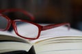 View on pages of open book with red reading glasses Royalty Free Stock Photo