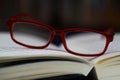 View on pages of open book with red reading glasses Royalty Free Stock Photo