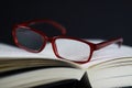 View on pages of open book with red reading glasses Royalty Free Stock Photo
