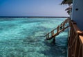 A view of the pale blue water of the lagoon. In the background is a dark ocean. On the right, the wooden tropical houses of the Royalty Free Stock Photo