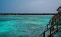 A view of the pale blue water of the lagoon. In the background is ocean. On the right, the wooden tropical houses of the holiday Royalty Free Stock Photo