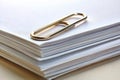 View of a paper clip with stack of blank paper