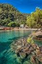 View of Paraggi bay with stones in clear water