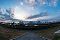 View of a park with buildings, a river and a bridge in the background during sunrise Royalty Free Stock Photo