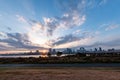 View of a park with buildings, a river and a bridge in the background during sunrise Royalty Free Stock Photo