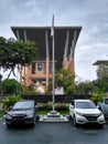 View of parking area and flagpole with building exterior of public library.