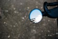 View of part modern building reflected in motorcycle round rear view