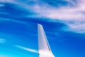 View of the part of a wing of an aeroplane or airliner in flight out of the window with blue sky and light clouds. Wing of Royalty Free Stock Photo