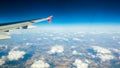 View from the passenger seat on airplane wing and clouds against blue sky Royalty Free Stock Photo