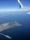 A view from the passenger window of a wing of a Westjet airplane flying above the ocean off of Victoria, British Columbia, Canada.