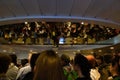 Many passengers waiting in lobby reflecting on the ceiling mirror