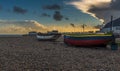 A view past boats on the beach at Worthing, Sussex, UK at sunset Royalty Free Stock Photo