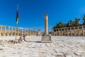 A view past a column across the Oval Plasa in the ancient Roman settlement of Gerasa in Jerash, Jordan