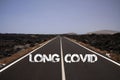 View on paved empty road through dry stony desert with text: long covid