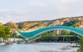 View on the Peace Bridge with the Sololaki Hill and old town buildings on the background, Tbilisi, Georgia Royalty Free Stock Photo