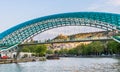 The view on the Peace Bridge with the Sololaki Hill and old town buildings on the background, Tbilisi, Georgia Royalty Free Stock Photo