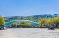 The view on the Peace Bridge with the Sololaki Hill and old town buildings on the background, Tbilisi, Georgia Royalty Free Stock Photo
