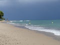 View of a peaceful sandy beach with yellow buoys drifting on the shore Royalty Free Stock Photo