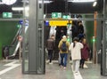 View of people taking the escalator - emergency exit arrows in a public building