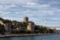 View of people walking by Bosphorus, historical fortress called Rumeli Hisari and FSM bridge in Istanbul. Royalty Free Stock Photo