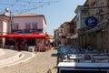 View of people walking on street, restaurants and old, historical, traditional stone houses in famous, touristic Aegean town