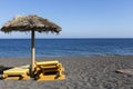 view of Perissa beach on the Greek island of Santorini with sunbeds and umbrellas. Beach is covered with fine black sand, and Royalty Free Stock Photo