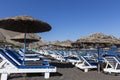 view of Perissa beach on the Greek island of Santorini with sunbeds and umbrellas. Beach is covered with fine black sand, and Royalty Free Stock Photo