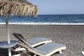 view of Perissa beach on the Greek island of Santorini with sunbeds and umbrellas. Beach is covered with fine black sand, and Royalty Free Stock Photo