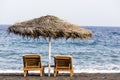 view of Perissa beach on the Greek island of Santorini with sunbeds and umbrellas. Beach is covered with fine black sand, and Royalty Free Stock Photo
