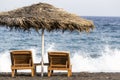 view of Perissa beach on the Greek island of Santorini with sunbeds and umbrellas. Beach is covered with fine black sand, and Royalty Free Stock Photo