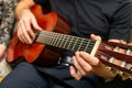 View of a person hand on a wooden handle near the strings of a guitar Royalty Free Stock Photo