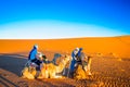 Persons doing camel trek in the desert of Morocco next to M`hamid