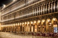 Piazza San Marco building illuminated at night, with table and chairs Venice Italy Royalty Free Stock Photo