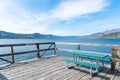 Picnic table on Naramata Wharf with scenic view of Okanagan Lake, mountains, and blue sky Royalty Free Stock Photo