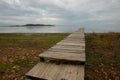 View of a pier on a lake with shore covered by autumn leaves