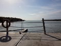 View from pier to water of sea in a nice day or evening with blues sky, bright sun and white clouds. The concept of a holiday on Royalty Free Stock Photo