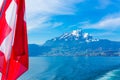 View of Pilatus Mountain and swiss flag from Lake Lucerne, Switzerland Royalty Free Stock Photo