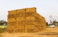 A view of piles of straw bales stacked on top of each other in an orderly large pile Royalty Free Stock Photo