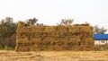 A view of piles of straw bales stacked on top of each other in an orderly large pile Royalty Free Stock Photo
