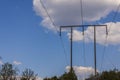 View of pillar high-voltage electric power transmission line against on blue sky with white clouds background. Royalty Free Stock Photo