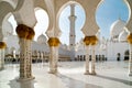 Columns and arches in the courtyard with view to domes and main building of Grand Mosque Abu Dhabi